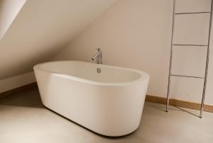 - une baignoire blanche dans une chambre avec plafond dans l'établissement La Pipistrelle Hotel, à Luxembourg