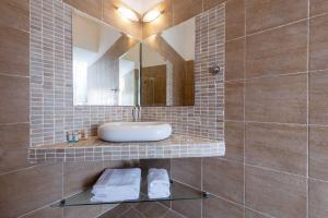 un bagno con lavandino e specchio di Red Cliff Santorini Villa - Volcano View & Jacuzzi ad Akrotírion