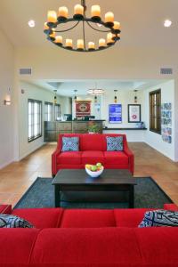 a living room with a red couch and a table at Lamplighter Inn & Suites at SDSU in San Diego