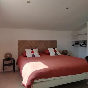 a bedroom with a bed with red sheets and white pillows at côté verdon 1 in Quinson