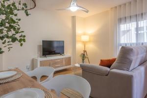 ein Wohnzimmer mit einem Sofa und einem TV in der Unterkunft Apartamento Caridad 14 Centro Histórico Cartagena in Cartagena