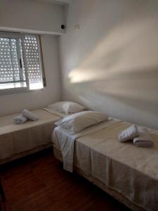 dwa łóżka w pokoju z oknem w obiekcie Alojamiento La Palmera w mieście Saladillo