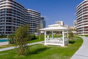 a white gazebo in a park with tall buildings at Beautiful Apartment with year round hot mineral pool and jakuzi in Varna City