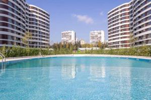 a large swimming pool in the middle of two buildings at Beautiful Apartment with year round hot mineral pool and jakuzi in Varna City