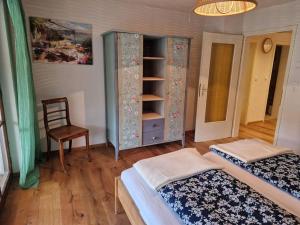 a bedroom with two beds and a cabinet and a chair at Ferienglück im Schwarzwald in Zimmern ob Rottweil