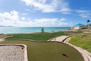 um campo de golfe com o oceano ao fundo em Anguilla - Villa Anguillitta villa em Blowing Point Village