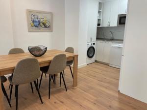 a dining room table with chairs and a kitchen at IZARRA by Smiling Rentals in Hondarribia