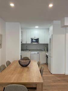 eine Küche und ein Esszimmer mit einem Holztisch und Stühlen in der Unterkunft IZARRA by Smiling Rentals in Hondarribia