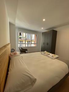 1 cama blanca grande en una habitación con ventana en IZARRA by Smiling Rentals, en Hondarribia