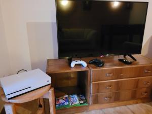 a living room with a television and a dresser with a video game controller at Chata Claudia in Zázrivá