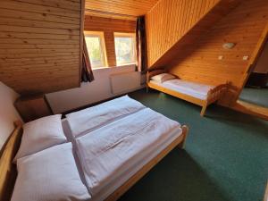 a bedroom with two beds in a wooden cabin at Chata Claudia in Zázrivá