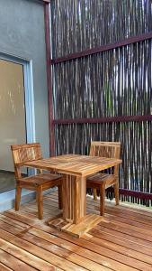 a wooden picnic table and two chairs on a deck at Bahía Santamaría in Moñitos