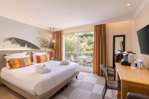 Habitación de hotel con cama, escritorio y ventana en Best Western Premier Montfleuri en Sainte-Maxime