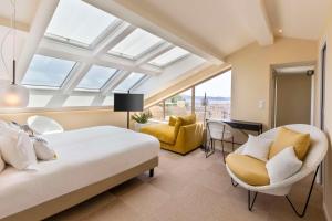 um quarto com uma cama, uma cadeira e uma janela em Best Western Premier Montfleuri em Sainte-Maxime