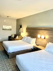 Habitación de hotel con 2 camas y sofá en Best Western Plus Pitt Meadows Inn & Suites, en Pitt Meadows
