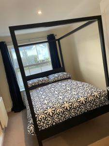 a bedroom with a canopy bed with a window at Sea-Haven on Sunrise Ground Floor Holiday Home The Bay Filey in Filey
