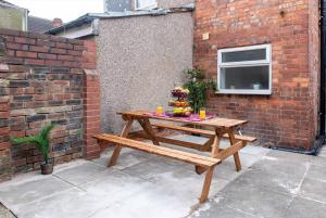 a wooden picnic table in front of a brick wall at Kingsway House in Coventry