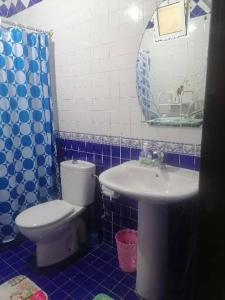 La salle de bains bleue et blanche est pourvue de toilettes et d'un lavabo. dans l'établissement Huge Cozy Apartment, à Larache