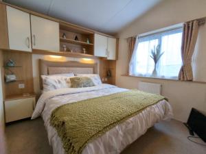 a bedroom with a large bed and a window at Peacehaven, Ynyslas, Borth in Borth