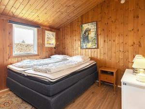 フレデリクスハウンにあるHoliday home Frederikshavn IIの木製の部屋にベッド1台が備わるベッドルーム1室があります。