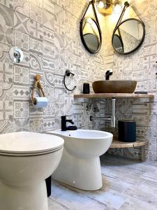 a bathroom with a toilet and a sink and mirrors at Il Pumo Rosa - Puglia Mia Apartments in Monopoli +18 photos