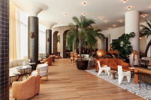 a lobby with tables and chairs and a lobby with trees at Santa Monica Proper Hotel, a Member of Design Hotels in Los Angeles