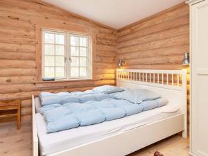 NordostにあるHoliday Home Kulmulevejの木製の壁の客室の白いベッド1台