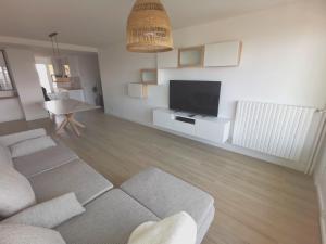 a living room with a couch and a flat screen tv at Ker Romain - Sea View - 3 bedrooms Appt in Saint Malo