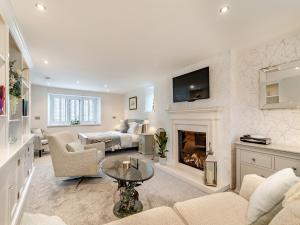 uma sala de estar com um sofá e uma lareira em Shireburn Cottage em Hurst Green