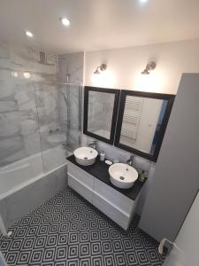 a bathroom with two sinks and a shower and a tub at Ker Romain - Sea View - 3 bedrooms Appt in Saint Malo