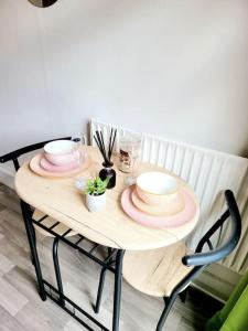 a wooden table with plates and dishes on it at One bedroom apartment with a terrace in Angel (Islington)! in London