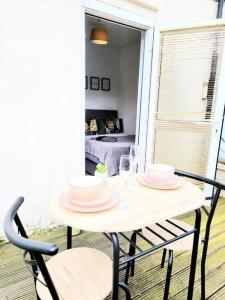 a white table with two chairs and plates on it at One bedroom apartment with a terrace in Angel (Islington)! in London