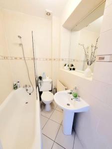 a white bathroom with a toilet and a sink at One bedroom apartment with a terrace in Angel (Islington)! in London