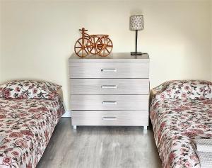 a dresser with a bike on top of it next to two beds at Apartamenty Marea Rentals przy Promenadzie Słońca Poddąbie in Poddąbie