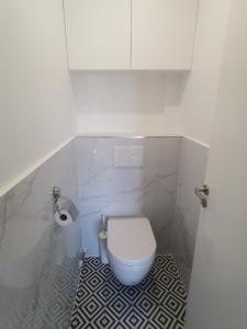 a bathroom with a white toilet in a stall at Ker Romain - Sea View - 3 bedrooms Appt in Saint Malo