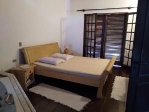 een slaapkamer met een bed en een raam bij Casa à 250m praia Martim de Sá, quiosques, restaurantes e lazer in Caraguatatuba
