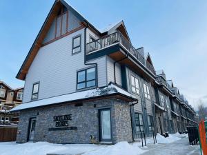 a large building with snow on the ground at Joes Brand New 2 King Bedrooms Townhome in Canmore in Canmore