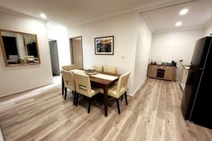 a dining room with a table and chairs and a refrigerator at The Retreat Terrigal 3bed 100m to beach in Terrigal