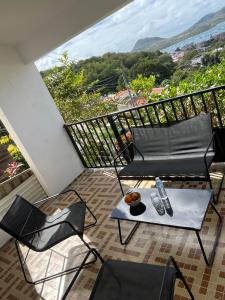 balcón con sofá, sillas y mesa en Maison Bel bonjou, en Le Marin