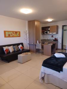 a living room with a couch and a kitchen at Lindo Flat em resort silencioso e aconchegante in Brasilia