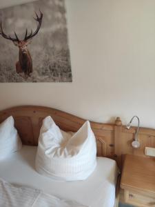 Schlafzimmer mit einem Bett mit einem Hirschbild an der Wand in der Unterkunft Landhaus Weißer Hirsch in Füssen