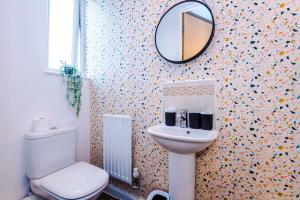 a bathroom with a toilet and a mirror on the wall at Rest&Recharge at a Spacious Townhouse by the Etihad (5mins to City Centre, Free Secure Parking) in Manchester