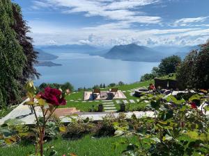 un jardín con vistas al lago y a las montañas en Private Luxury Spa & Silence Retreat with Spectacular View over the Lake Maggiore, en Stresa