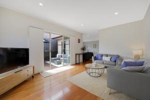 a living room with a couch and a tv at Hillside - Family Orientated Holiday Home in Warrnambool