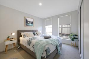 a white bedroom with a bed and a window at Hillside - Family Orientated Holiday Home in Warrnambool