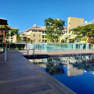 a boardwalk and a pool of water with buildings at Lindo Flat em resort silencioso e aconchegante in Brasília