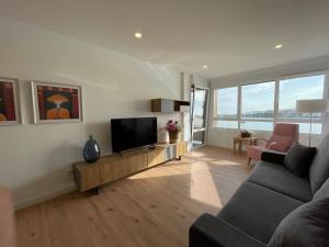 a living room with a couch and a television at IBAIA by Smiling Rentals in Hondarribia