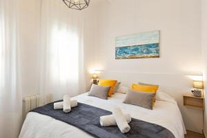 sypialnia z łóżkiem z ręcznikami w obiekcie Confort apartamentos en playa, 3 DRM w Barcelonie
