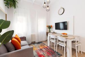 Confort apartamentos en playa, 3 DRM في برشلونة: غرفة معيشة مع طاولة وأريكة