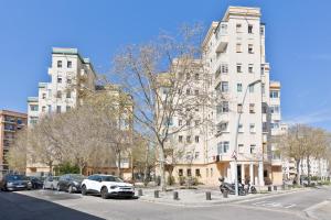 Confort apartamentos en playa, 3 DRM في برشلونة: شارع فيه سيارات تقف امام مباني طويلة
